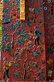 Wat Xieng Thong temple in Luang Prabang, Laos. the Ho Tai, the library. Colourful glass mosaics on a pink background with scenes of daily life. 